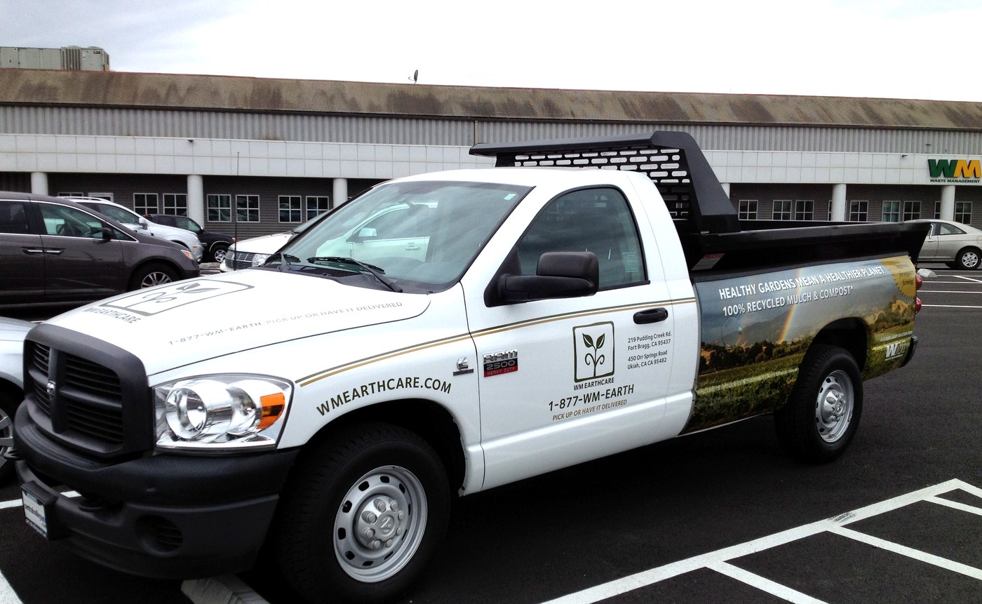 WM EarthCare branded pickup truck — driver side, showing logo, tagline and landscape photography wrap